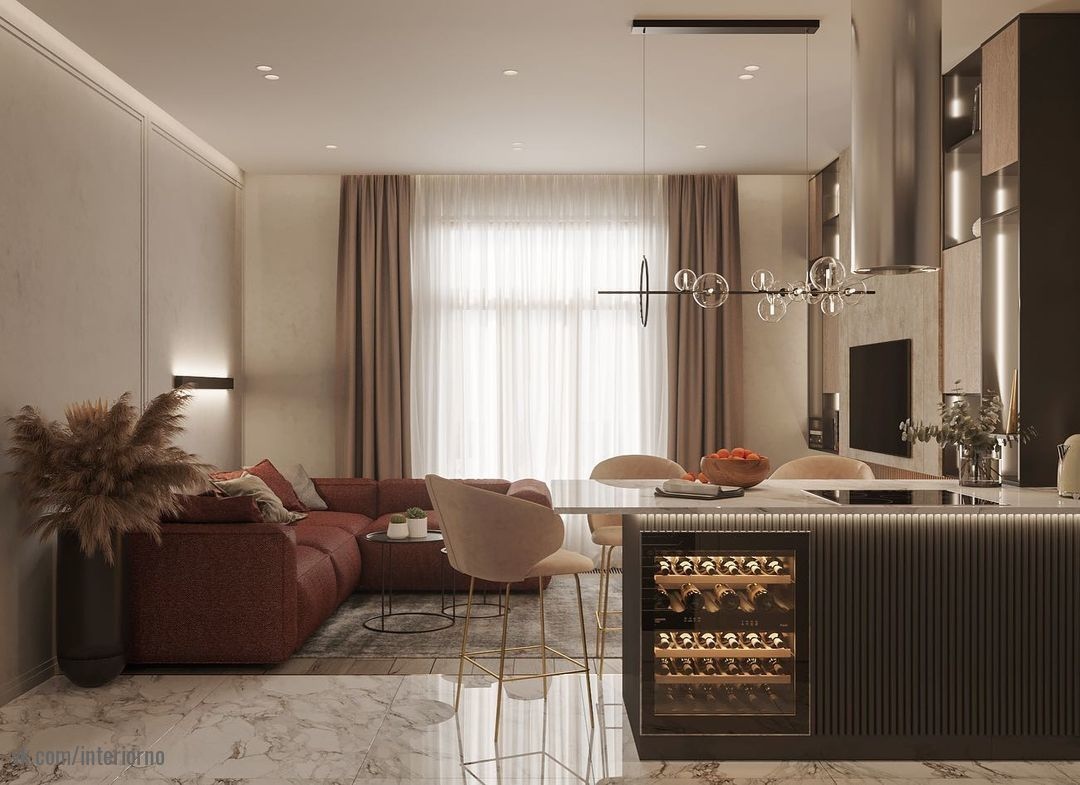 Современная кухня-гостинная выполнена в теплых постельных тонах, что придают ей спокойные и безмятежные нотки уюта.